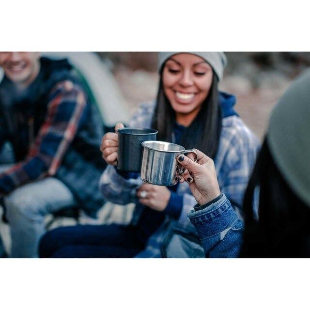 Friends camping outdoors holding Stansport aluminum drink cups by a tent