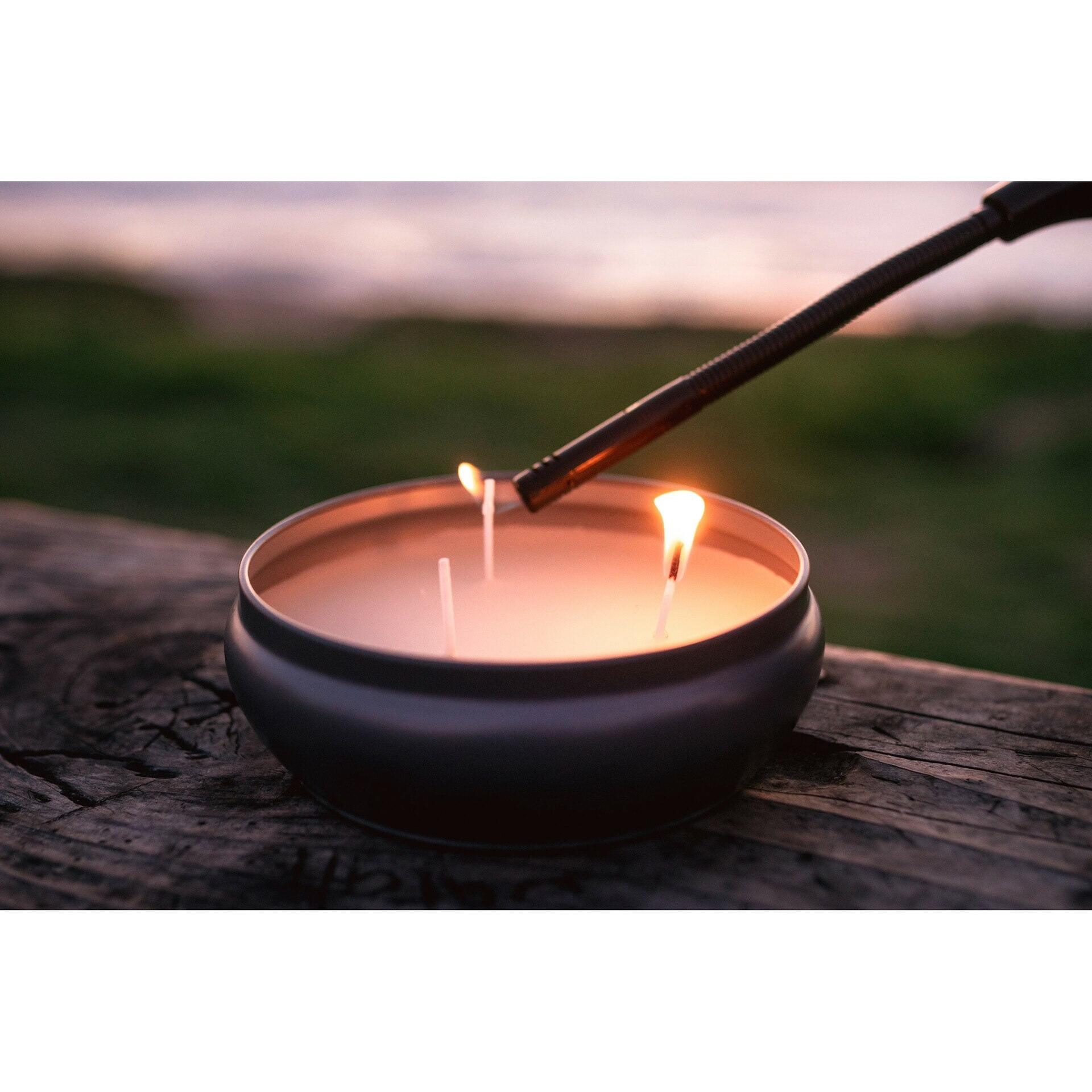 Lighting a Stansport citronella insect repellent candle outdoors on a wooden surface