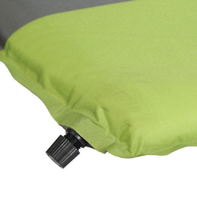 Close-up of green self-inflating air mat with black valve, compact camping sleeping pad