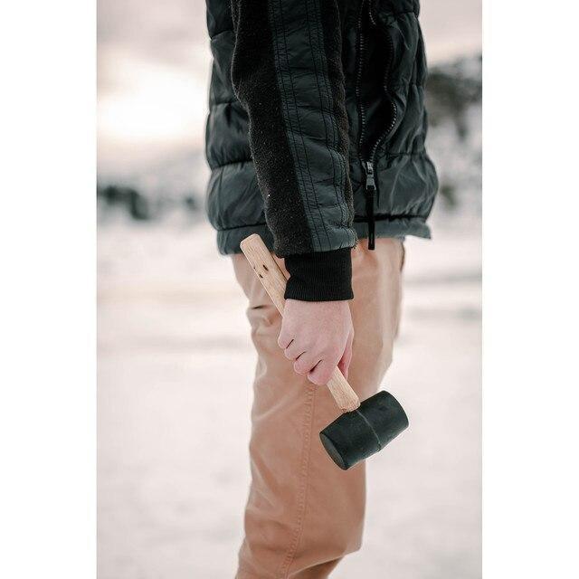 Person outdoors holding Stansport rubber tent peg mallet with wooden handle