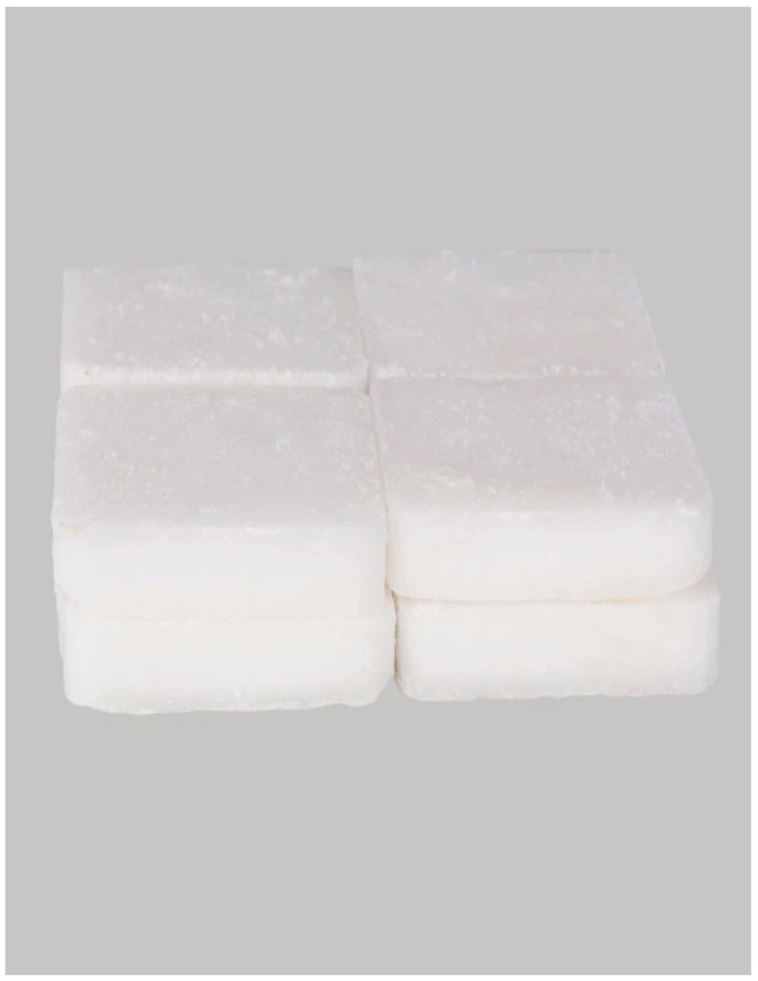 Eight white solid fuel tablets stacked on a plain grey background