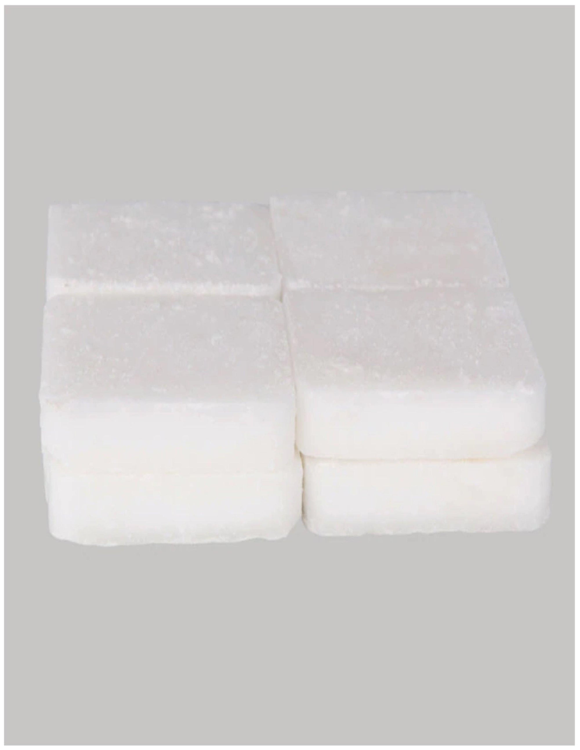Eight white solid fuel tablets stacked on a plain grey background