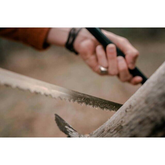 Hand sawing wood outdoors with Stansport utility steel bow saw