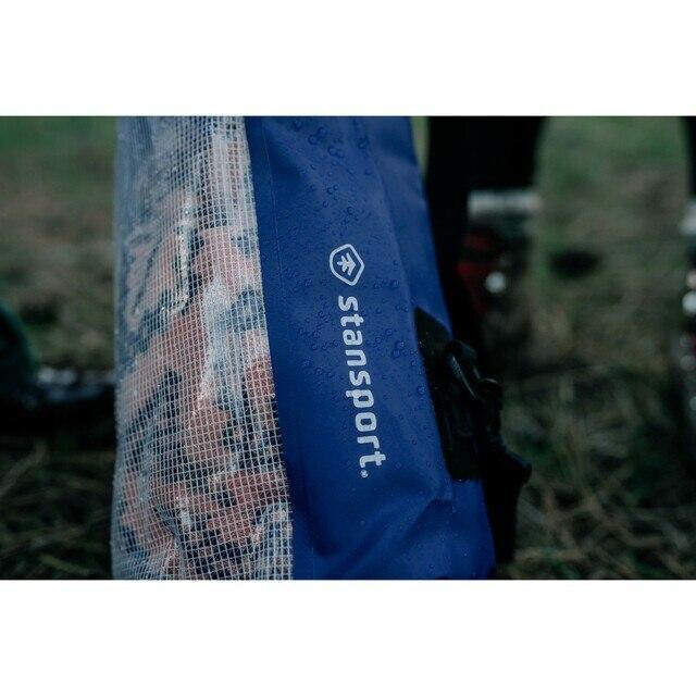 Blue Stansport waterproof dry bag with mesh side outdoors on wet grass