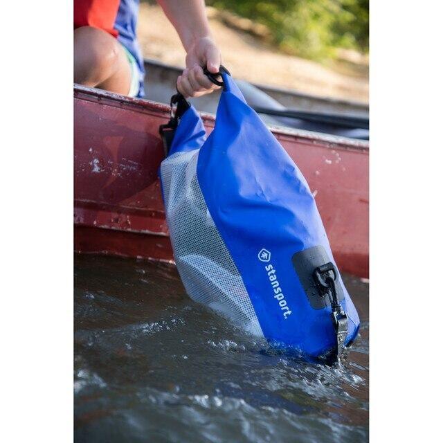 Blue Stansport waterproof dry bag being lifted from water next to a red canoe