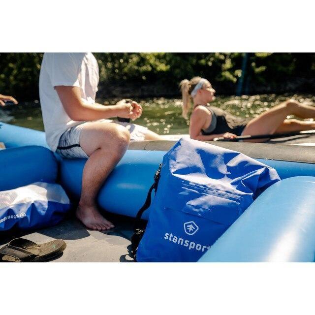 Stansport waterproof dry bag 30L on inflatable raft beside people relaxing by the water