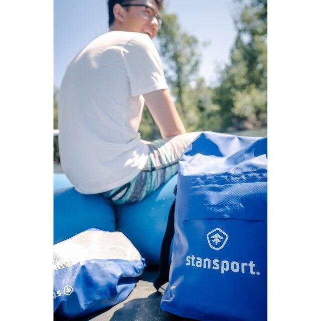 Stansport blue waterproof dry bags outdoors with a person sitting on inflatable raft