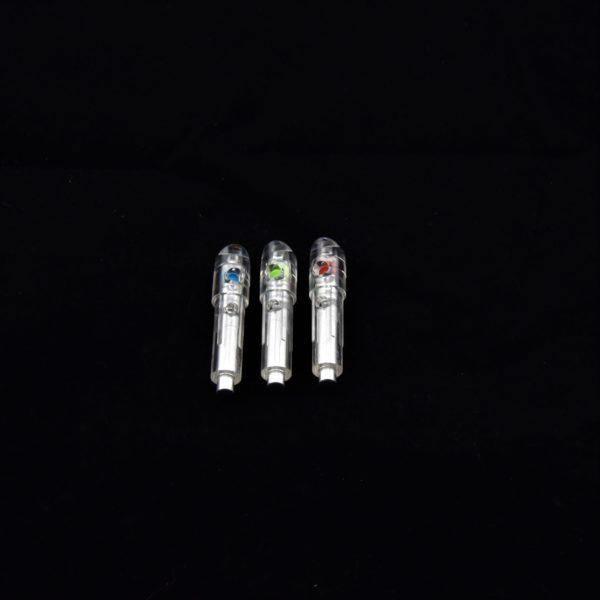 Three clear lighted nocks for crossbow arrows with colored tips on a black background